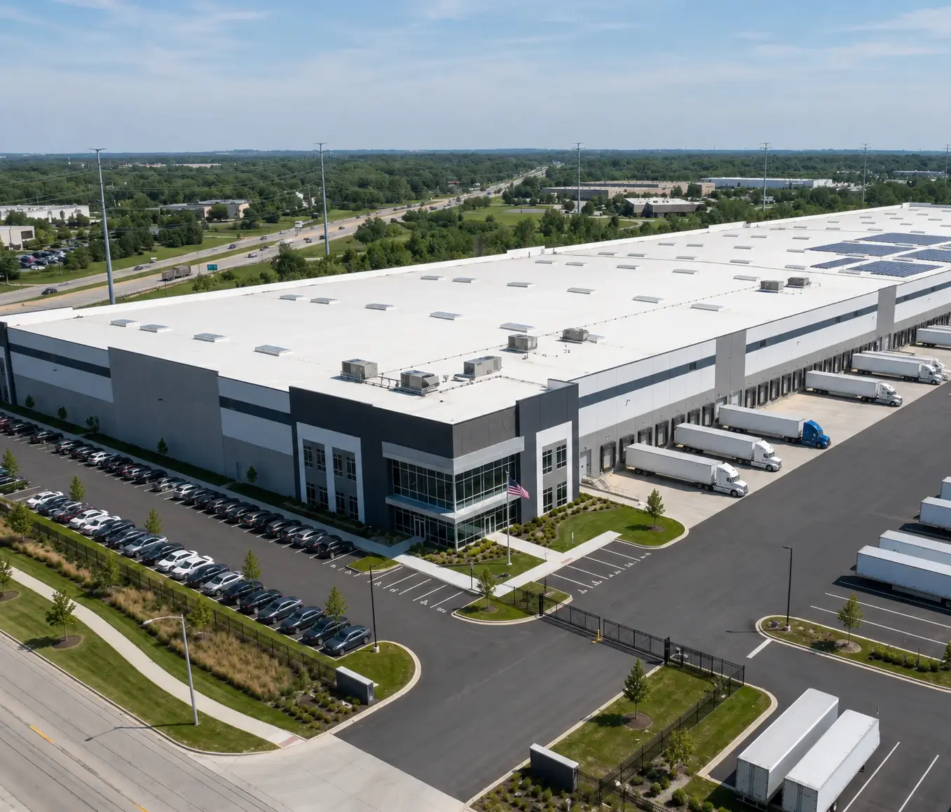 Wide-angle architectural view of a large contemporary logistics distribution center and industrial commercial property in DuPage County featuring multiple active loading docks.