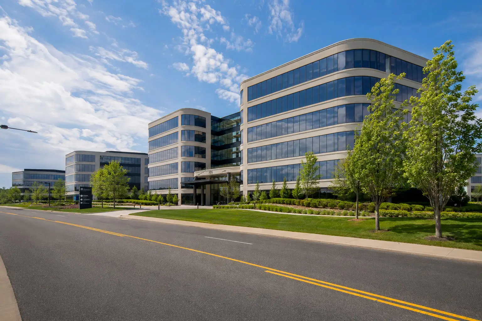 Elevated wide view of a modern Elk Grove Village commercial business district featuring glass office towers and mixed-use properties at golden hour.