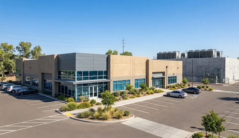 An exterior view across a commercial parking lot toward a modern suburban retail shopping center strip mall.